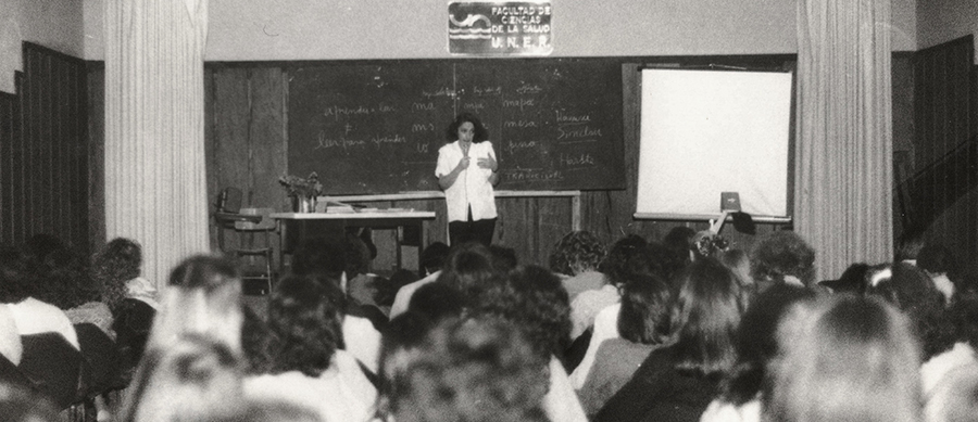 docente en un aula dictando una clase